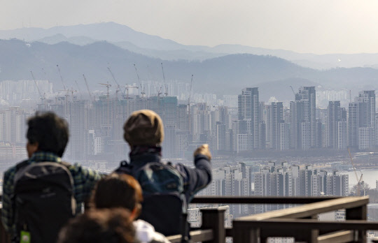 시민들이 서울 남산에서 도심 아파트 밀집 지역을 바라보고 있다. <연합뉴스>